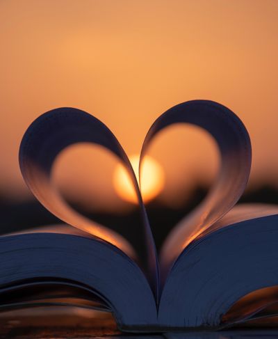 book pages forming a heart against the sun